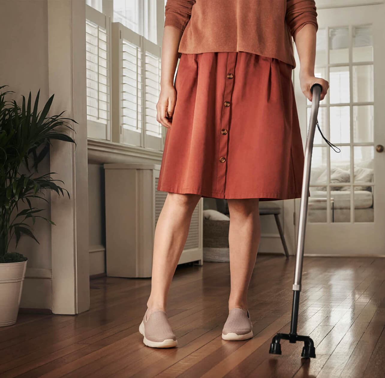 Image of a woman standing with a cane